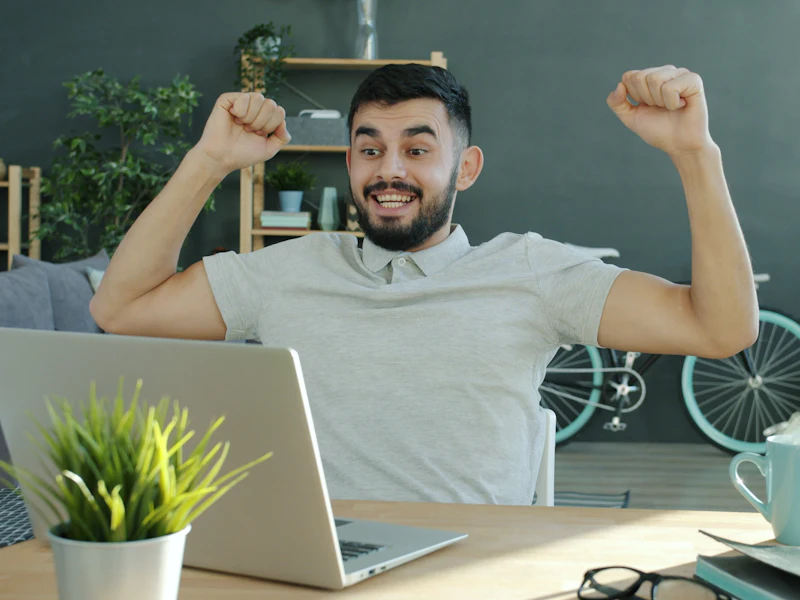 Business owner celebrating at his laptop